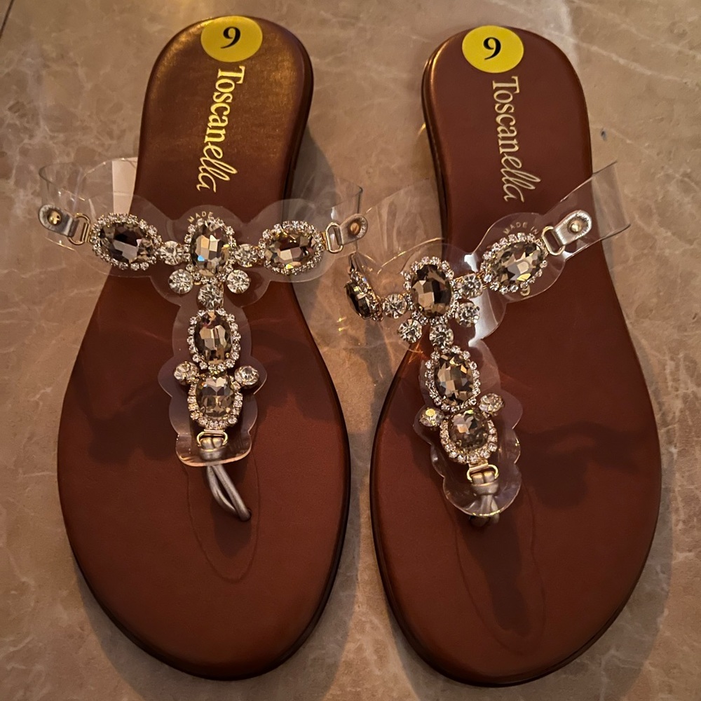 Brown slippers with gold embellishments on the top